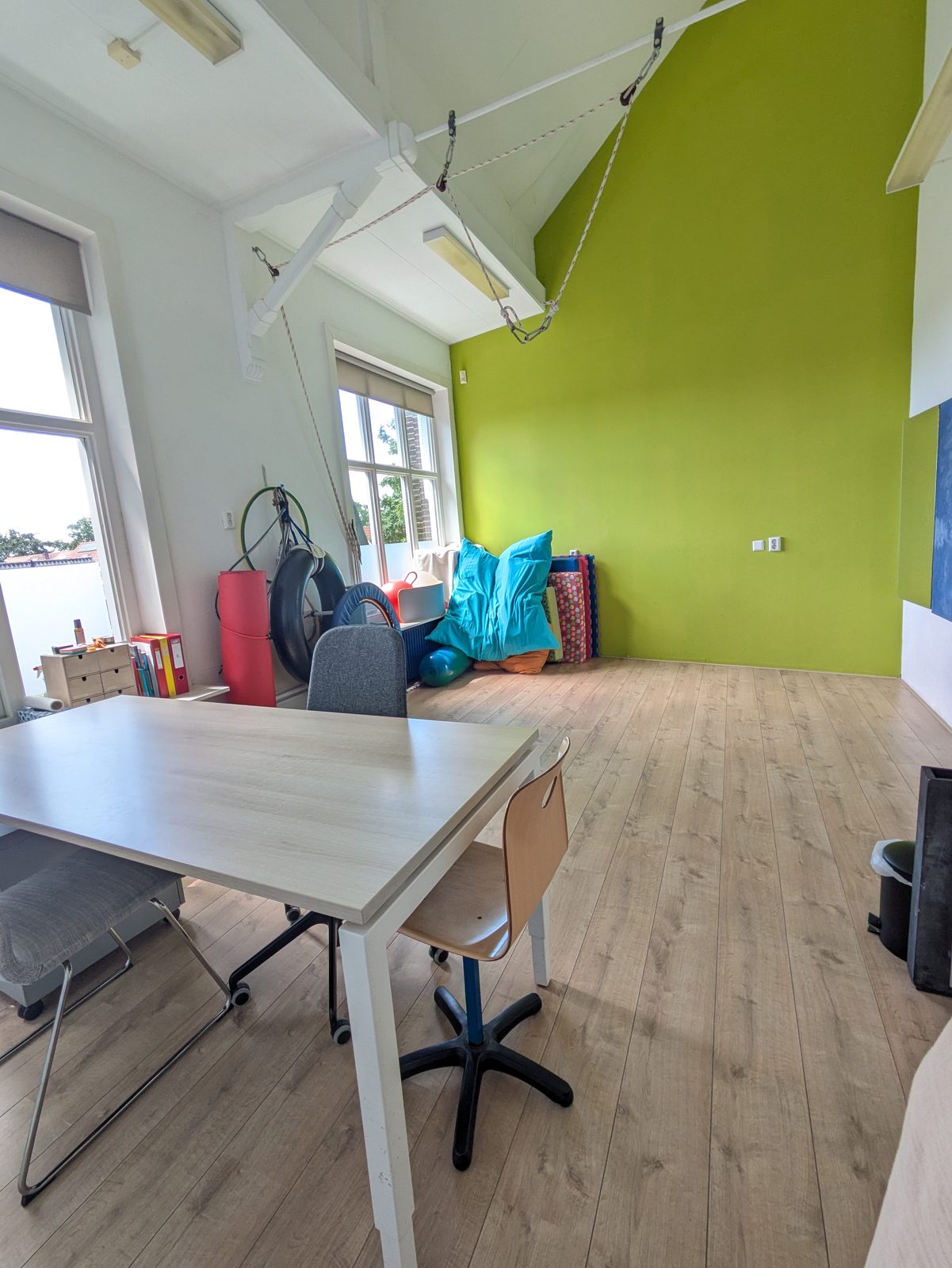 Overzicht behandelruimte met groene accentwand